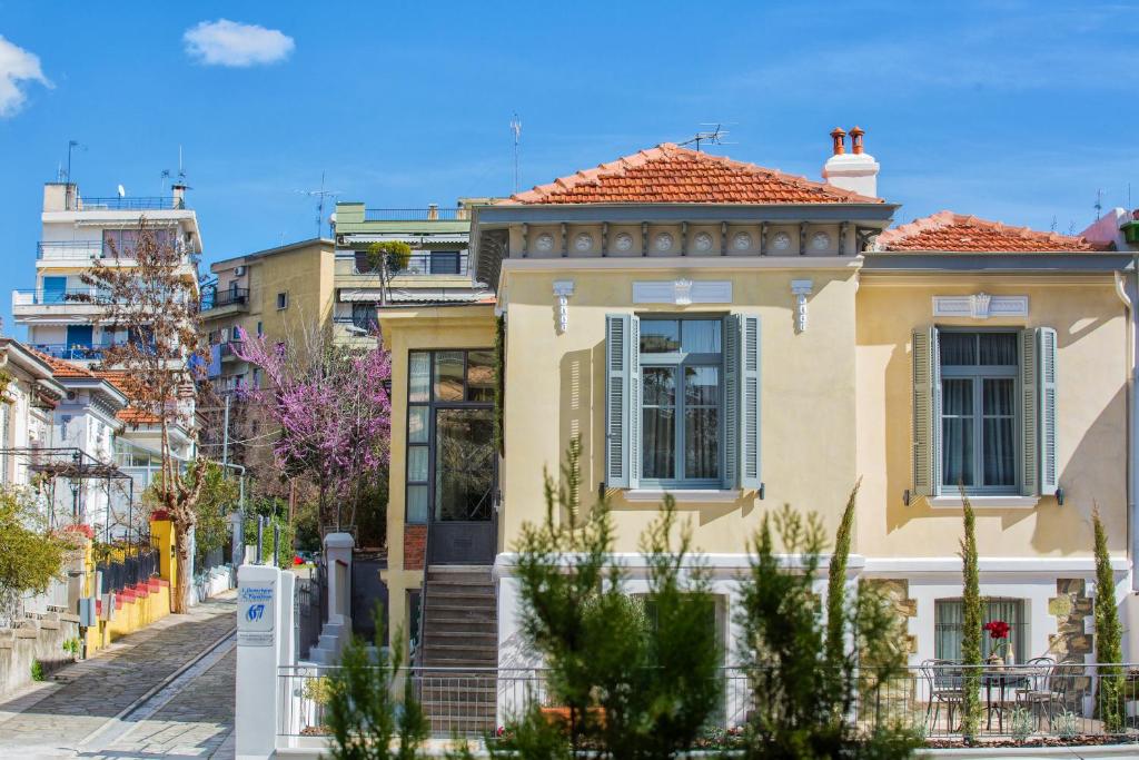 uma casa amarela com um telhado vermelho numa rua em Classic Villas Ouziel em Tessalônica