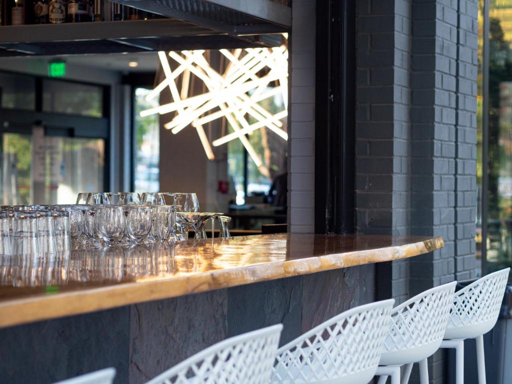 a bar with white chairs and wine glasses at Hotel Indigo Chattanooga - Downtown by IHG in Chattanooga