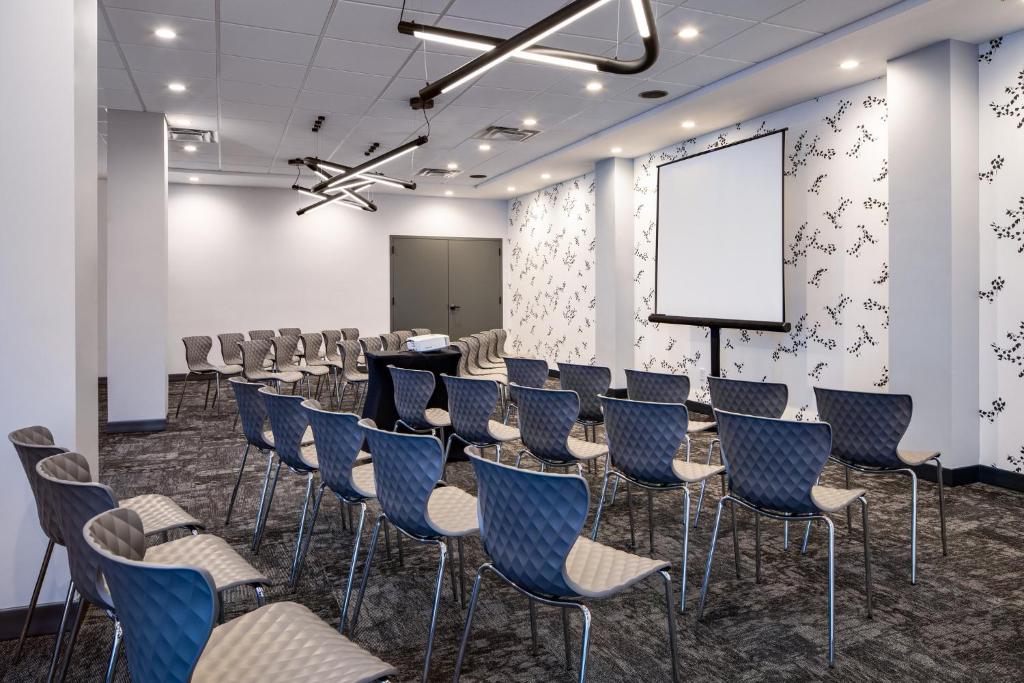 a conference room with chairs and a projection screen at Hotel Indigo Chattanooga - Downtown by IHG in Chattanooga