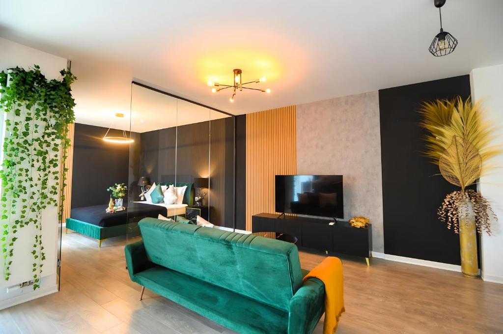 - un salon avec un canapé vert et une télévision dans l'établissement Elite Studio, à Bucarest