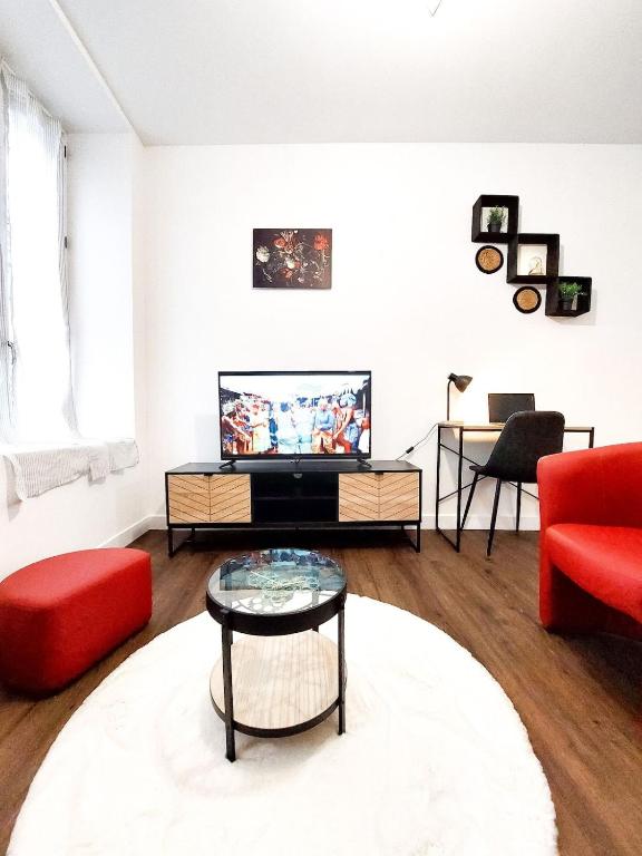 un salon avec un canapé rouge et une télévision dans l'établissement T2 centre-ville - gare, à Quimper
