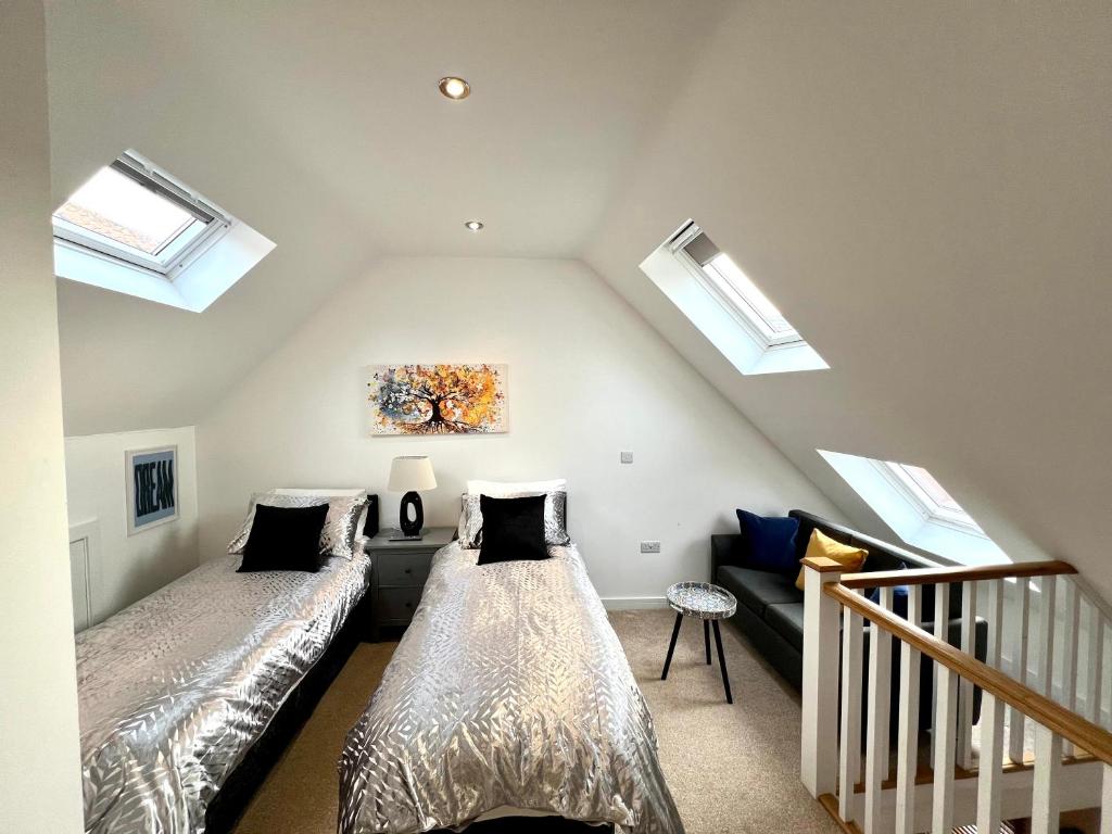 a attic bedroom with two beds and skylights at Glastonbury Sacred Vault, Split-Level, 1 Bedroom in Glastonbury