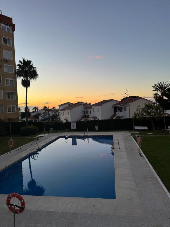 a swimming pool with a sunset in the background at El Nido de Mijas in La Cala de Mijas