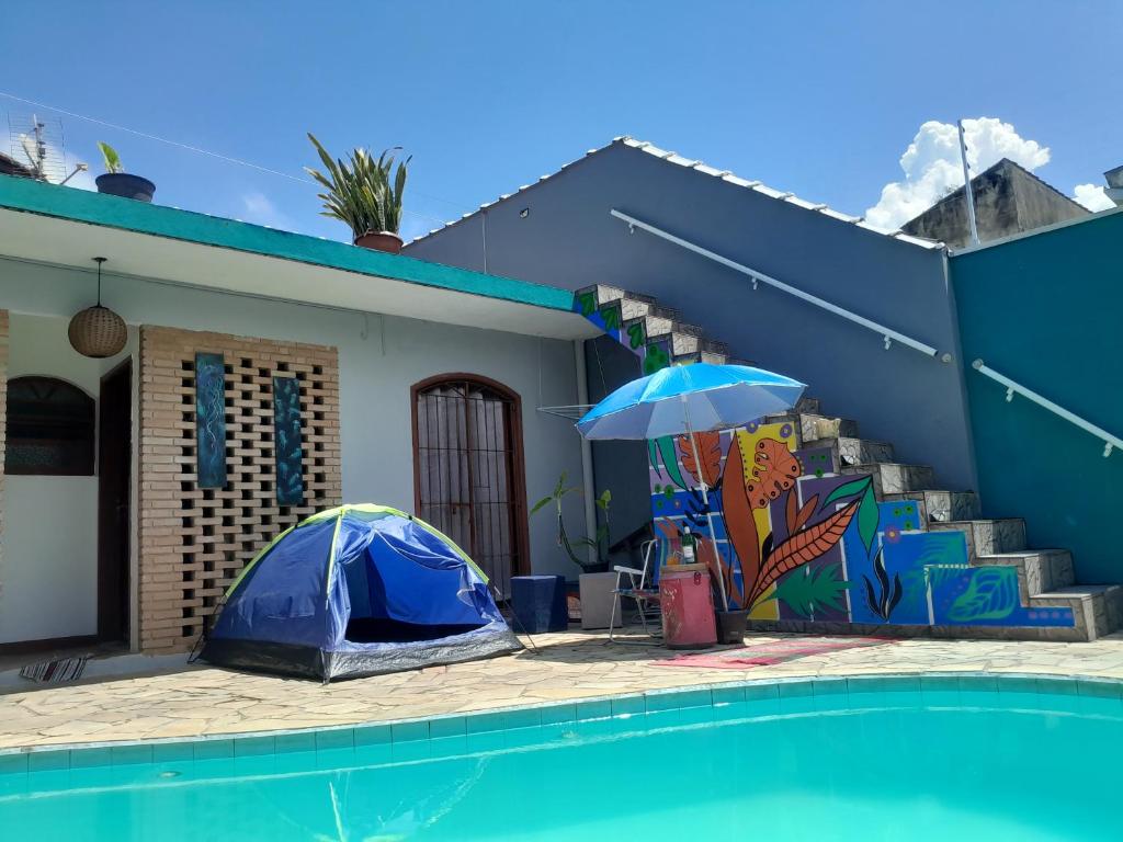a house with a blue tent next to a pool at CASA 51 HOSTEL ubatuba in Ubatuba