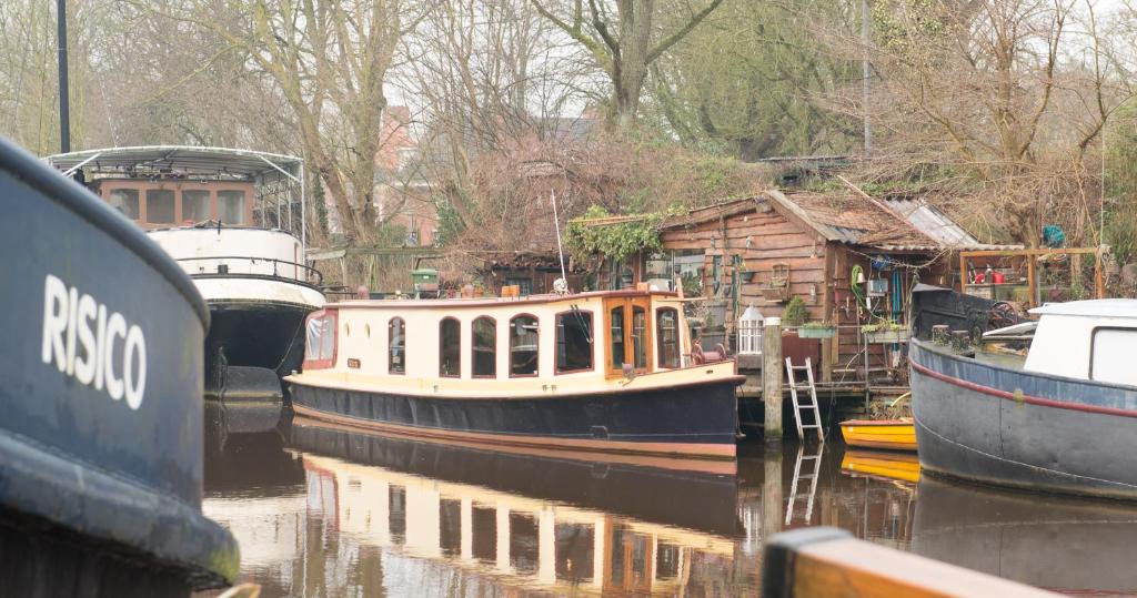 two boats are docked in the water next to a house at Salonboot de Wending in Groningen
