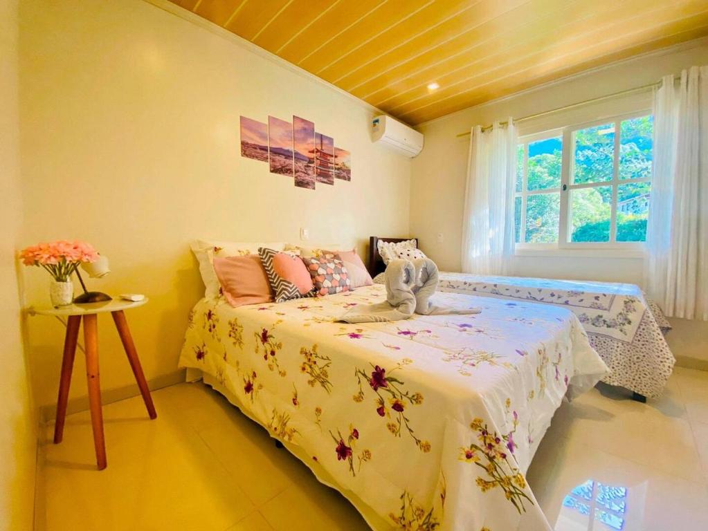 ein Schlafzimmer mit einem Bett und einem Fenster in der Unterkunft Casa ampla e aconchegante em Gramado in Gramado