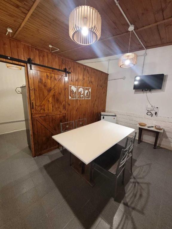 a white table in a room with two chairs at Casita Las Lavandas in El Bolsón