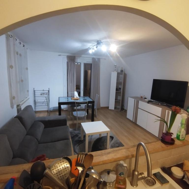 un salon avec un canapé et une télévision dans l'établissement T3 calme et lumineux, à Menton