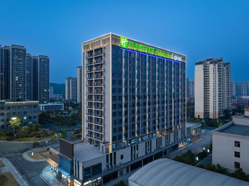a tall building with a green sign on top of it at Holiday Inn Express Chenzhou Suxian by IHG in Chenzhou