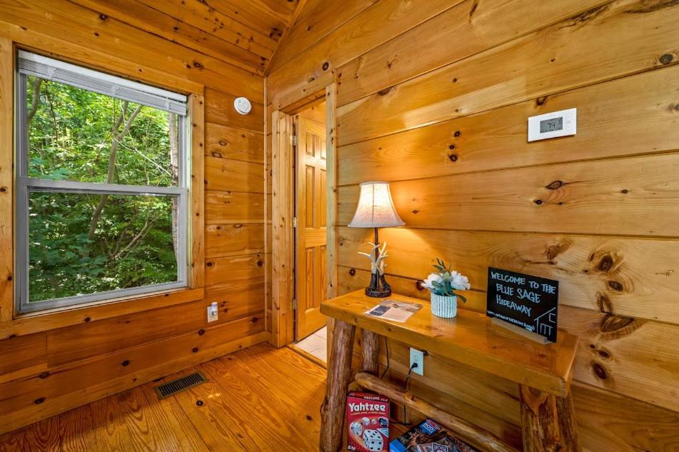 a log cabin with a table and a window at Gorgeous Lovers Retreat! 5 star rated, Free Tix to Dollywood, etc Hot tub, Indoor Jacuzzi, Views! in Sevierville