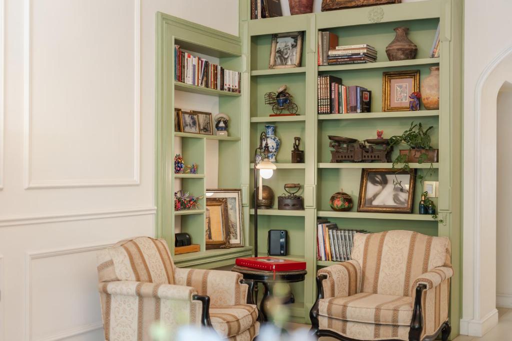 a living room with two chairs and a book shelf at Villa Ganz Boutique Hotel in Guadalajara