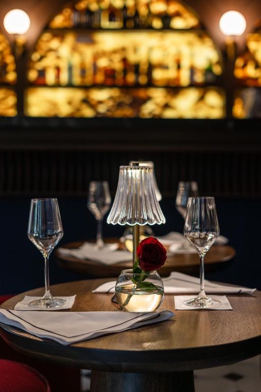 a table with a rose and two wine glasses at Villa Ganz Boutique Hotel in Guadalajara