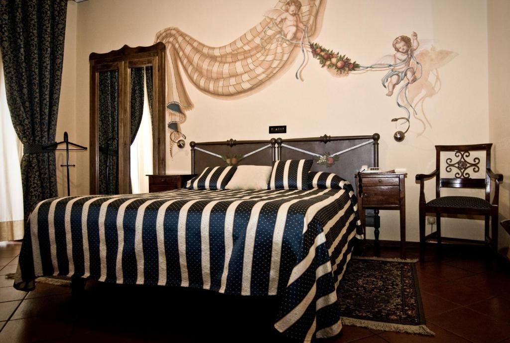 a bedroom with a bed with a black and white striped blanket at Hotel Regina in Pinerolo