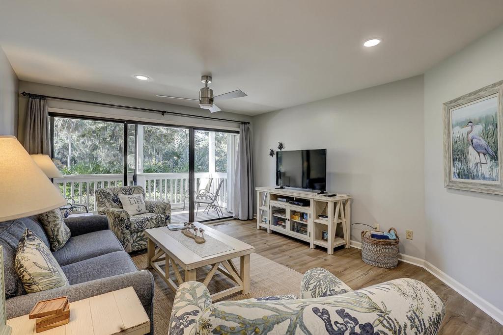 a living room with a couch and a tv at Wonderful luxury condo with great golf views K Bed Beach gear & bike rentals in Hilton Head Island