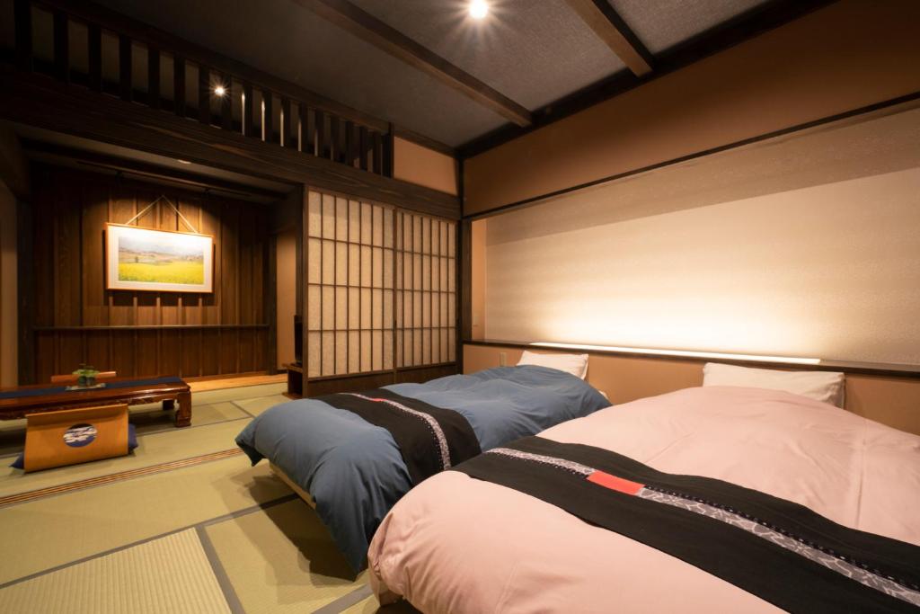 Postel nebo postele na pokoji v ubytování Kawaichiya Ryokan