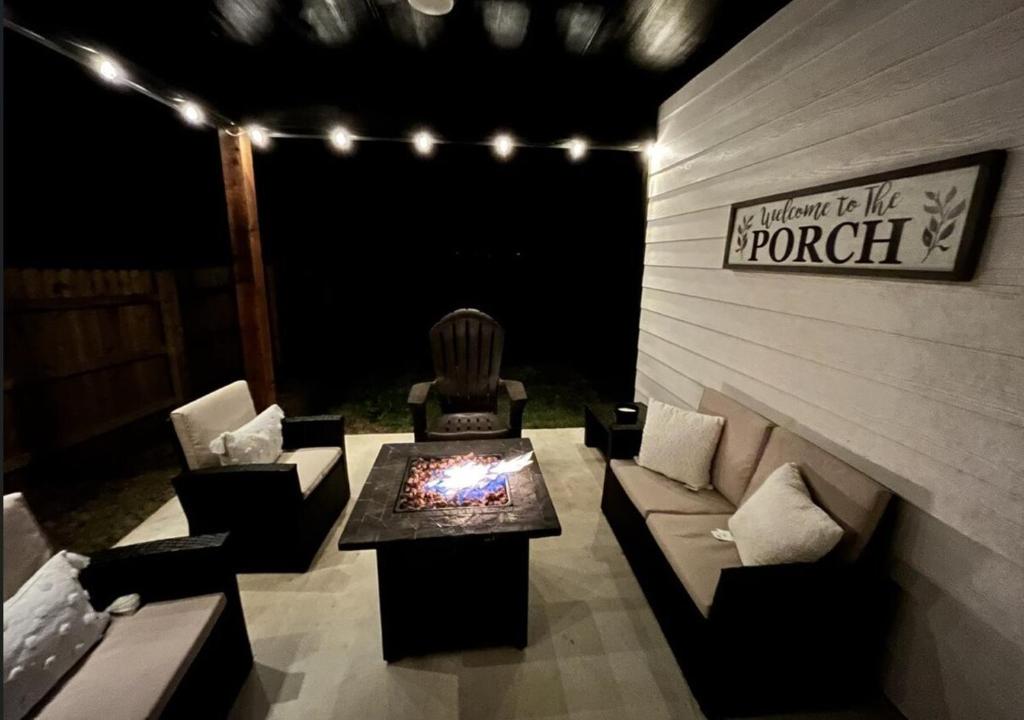 a patio with couches and a fire table and lights at New Stunning and Vibrant Kitchen-Smart TVs-Modern Gas Firepit-Free Parking in Granbury