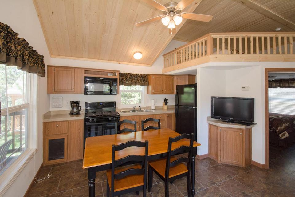 a kitchen with a wooden table with chairs and a ceiling fan at Yogi Bear's Jellystone Park Camp-Resort in Estes Park in Estes Park