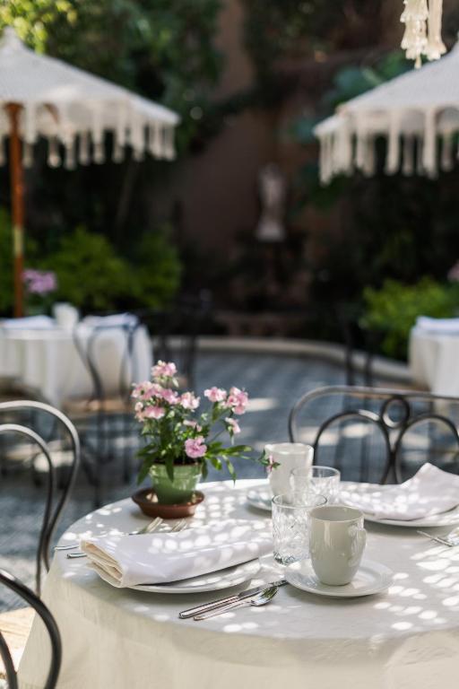 a table with plates and cups and flowers on it at Villa Ganz Boutique Hotel in Guadalajara