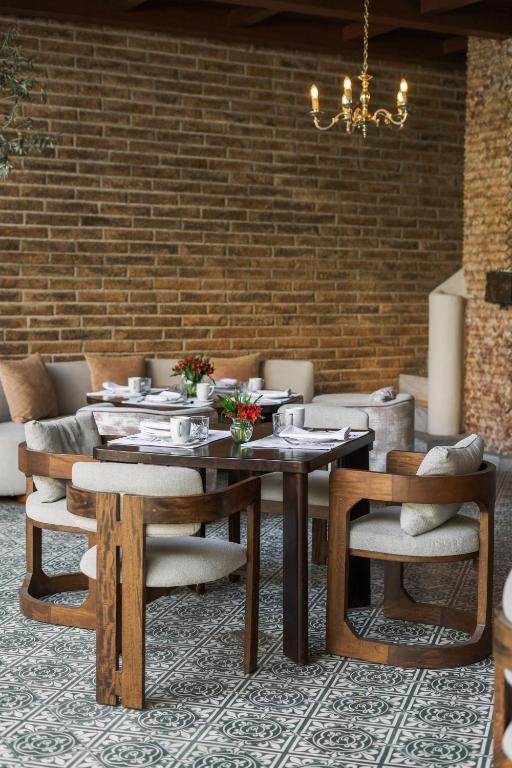 a dining room with a table and chairs and a brick wall at Villa Ganz Boutique Hotel in Guadalajara