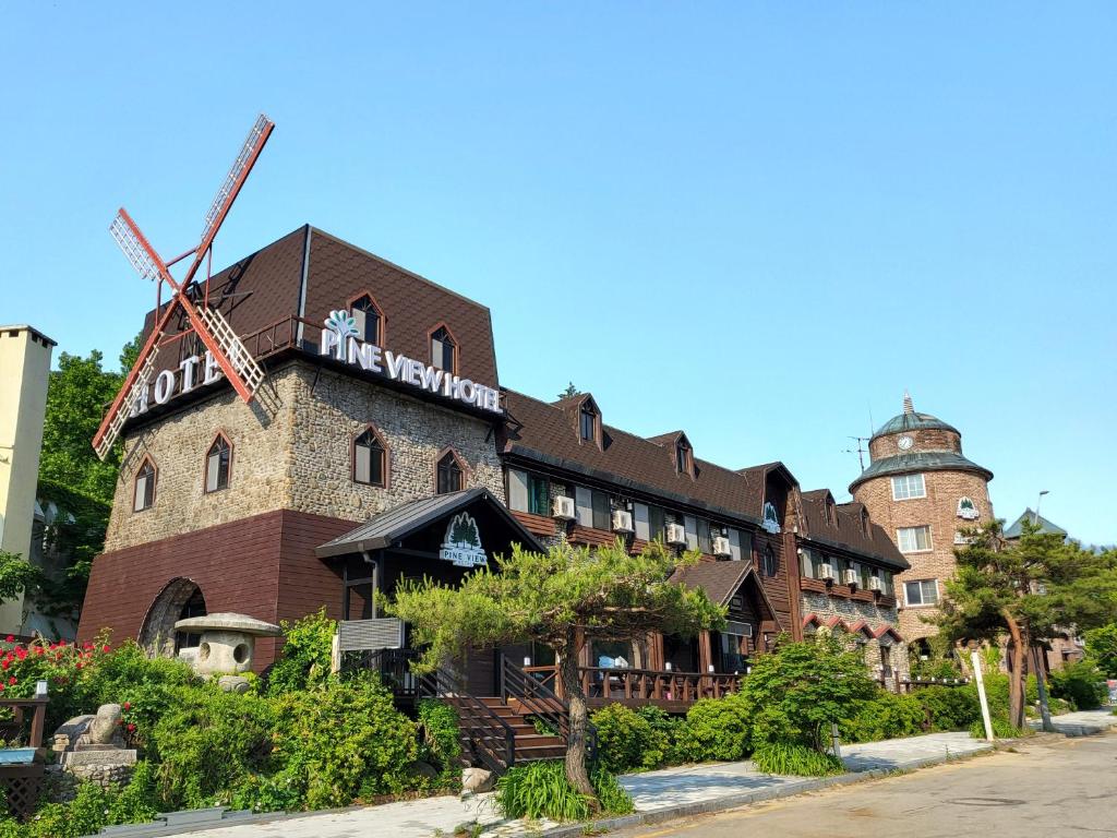 een gebouw met een windmolen aan de zijkant bij Sokcho Pine View Hotel in Sokcho