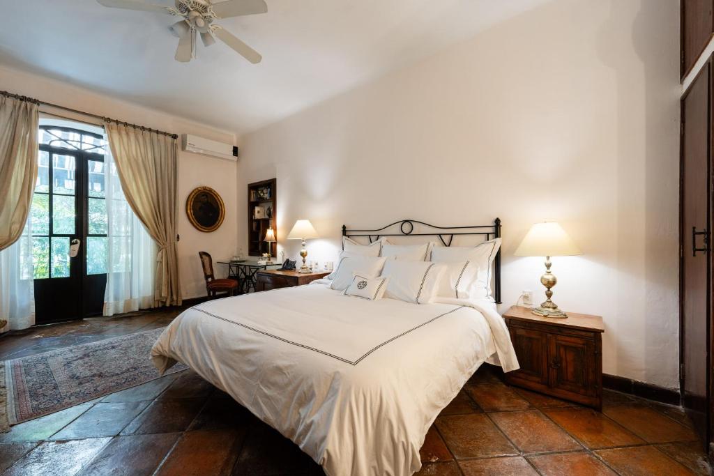 a bedroom with a large bed and a ceiling fan at Villa Ganz Boutique Hotel in Guadalajara