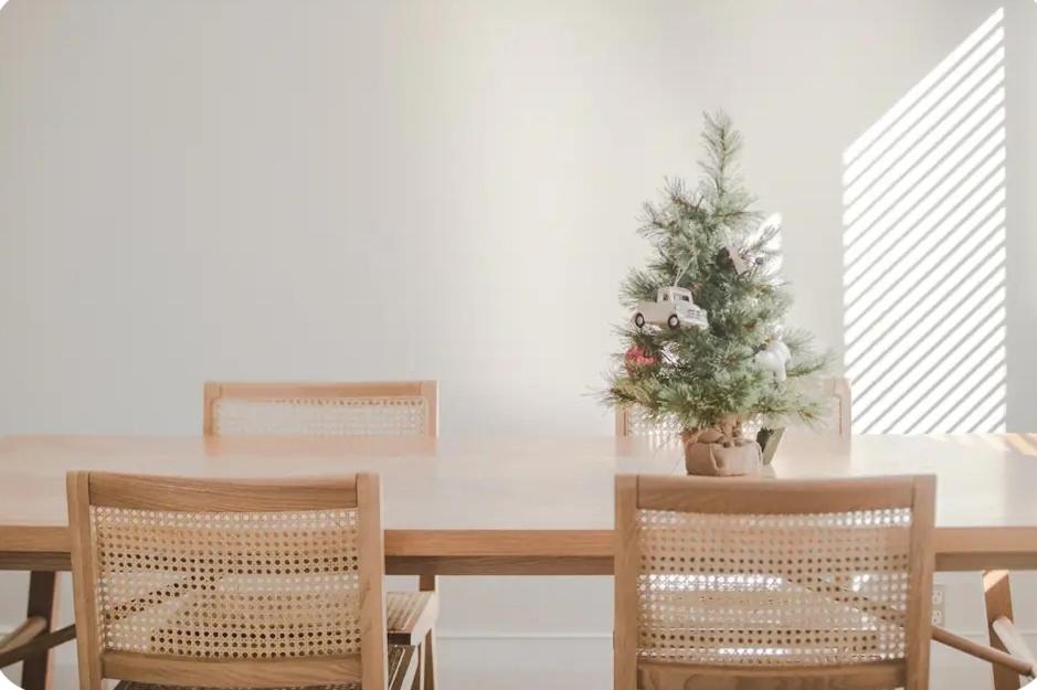 a dining room table with a christmas tree and two chairs at Outdoor Living at Its Finest in Auckland