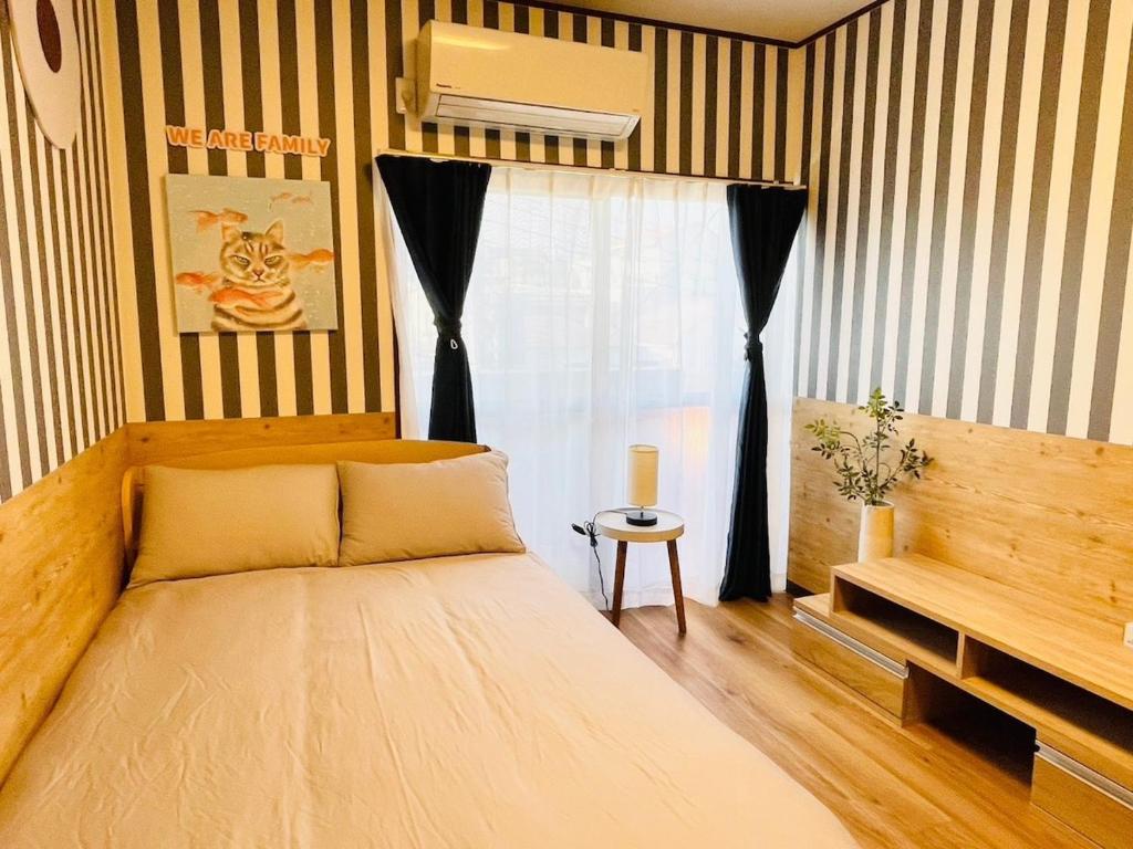 a bedroom with a large bed and a window at Koguma Shizuka in Osaka