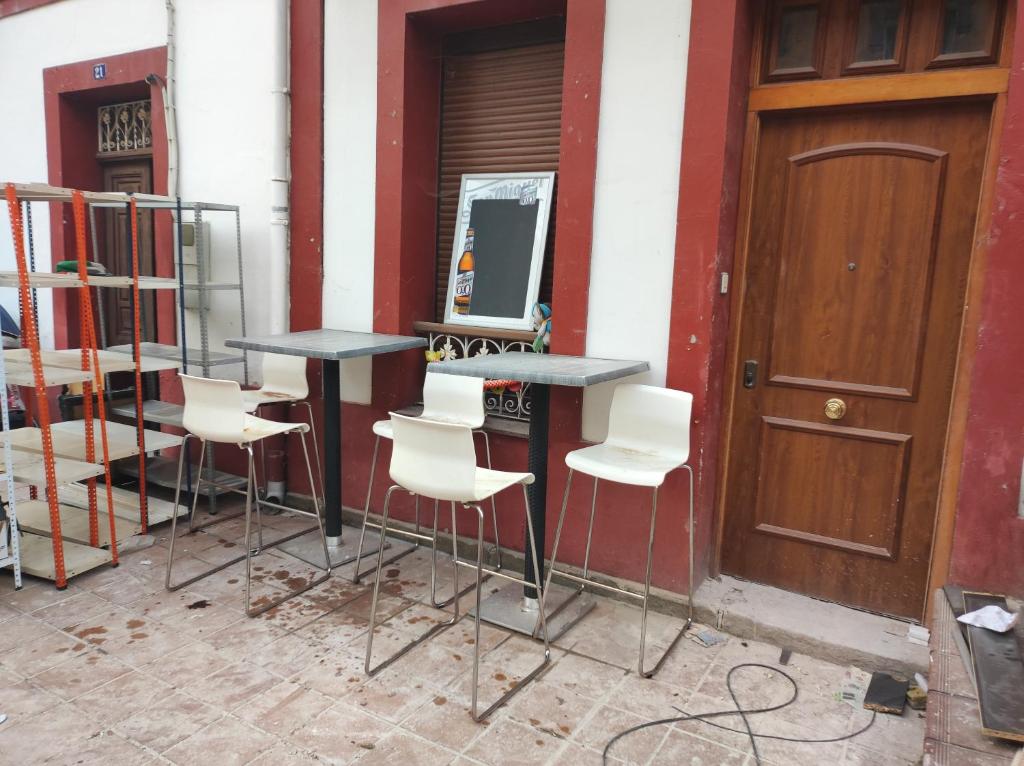 a group of chairs and tables in front of a building at Apartamento Rural Casa Carolina in Brañella
