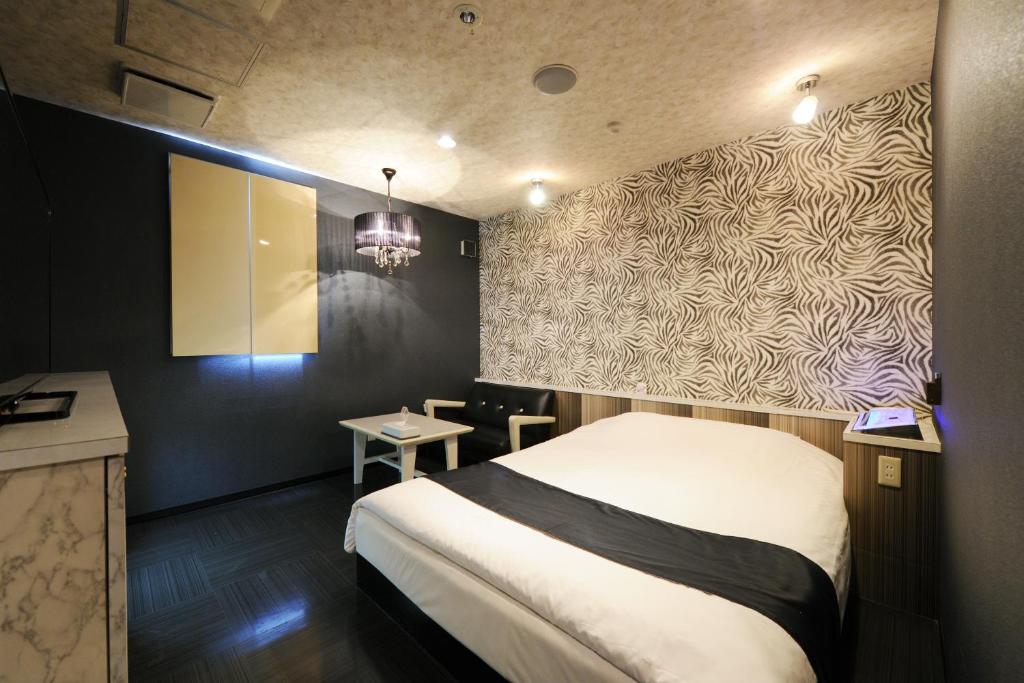 Postel nebo postele na pokoji v ubytování ホテルぴみ袋井店 大人専用