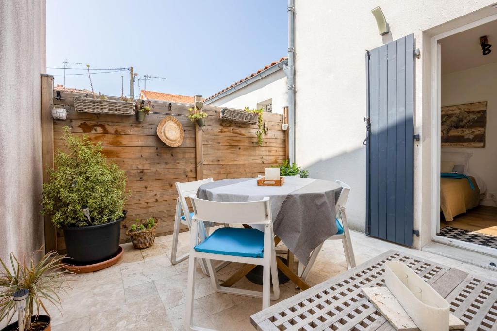 Elle comprend une petite terrasse avec une table et des chaises blanches. dans l'établissement Cosy courtyard apartment within 15min walk from old town, à La Rochelle