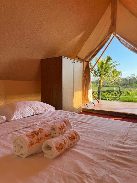 a bedroom with a bed with a large window at The Lake Farm - Dak Lak in Buon Ma Thuot