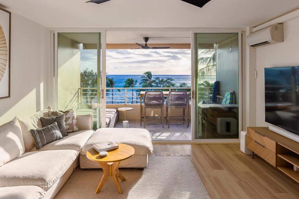 a living room with a couch and a television at Luxury condo 180 Ocean Views Steps to Beach in Kihei