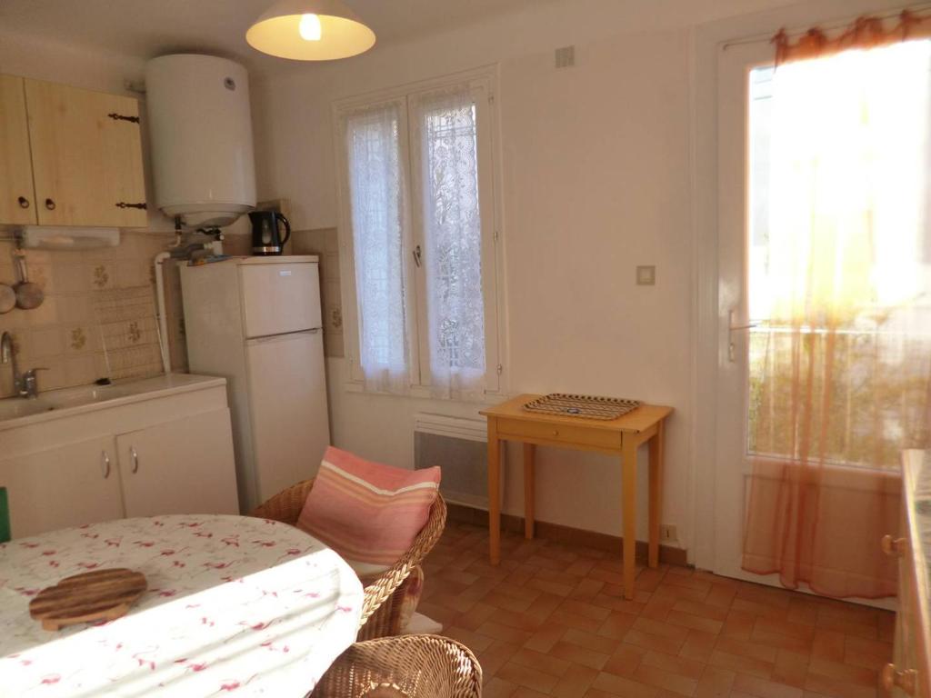 une petite cuisine avec une table et un réfrigérateur dans l'établissement T3 pour 4 avec Parking à Balaruc-les-Bains - FR-1-571-66, à Balaruc-les-Bains