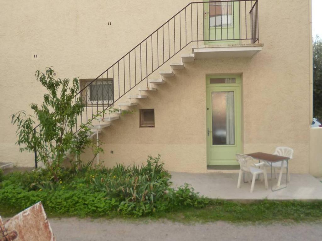 une maison avec une porte verte, une table et un escalier dans l'établissement T2 Confort avec Parking Proche Centre-ville - FR-1-571-70, à Balaruc-les-Bains