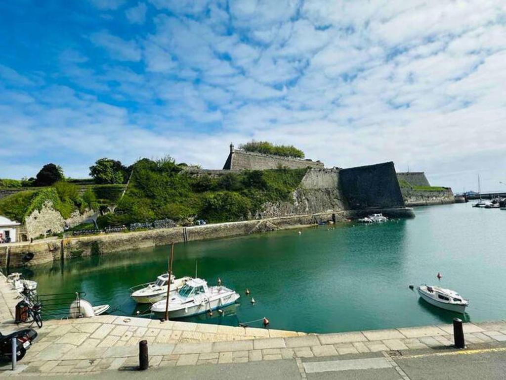 two boats are docked in the water near a castle at Triplex au cœur de Le Palais avec Wifi, près de la plage - FR-1-418-261 in Le Palais