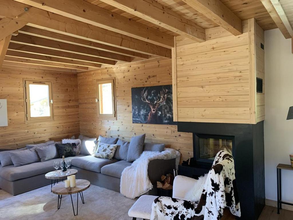 un salon avec un canapé et une cheminée dans l'établissement Chalet cosy à Montgenèvre avec cheminée et WIFI - FR-1-266-244, à Montgenèvre