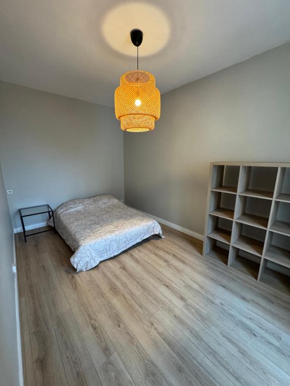 une chambre avec un lit et un lustre dans l'établissement 2 bedroom Apartment Reims, à Reims