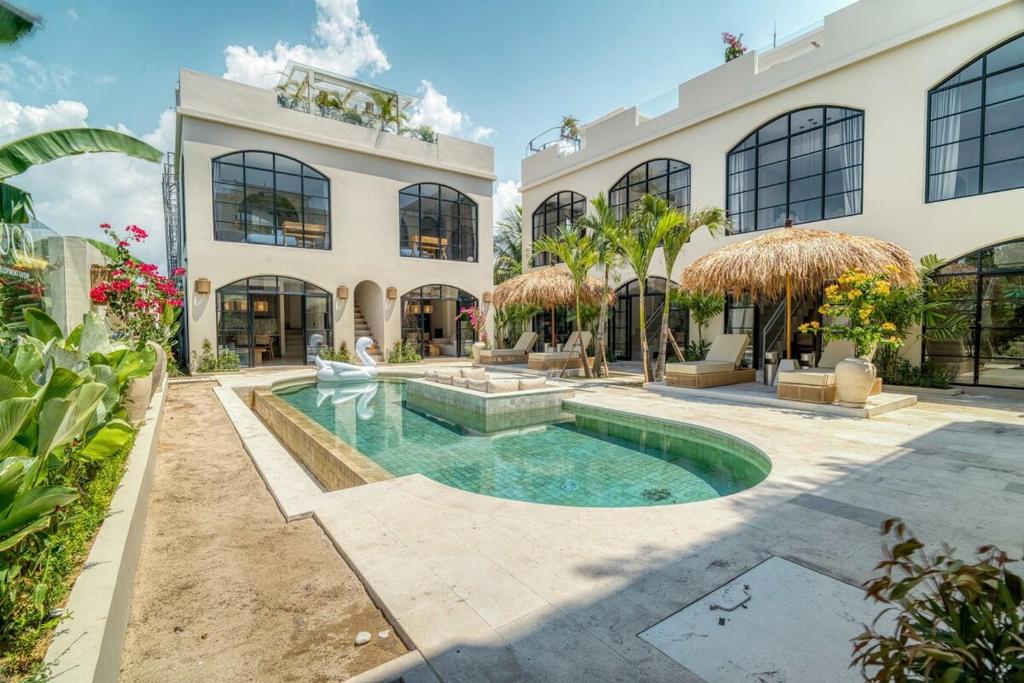 an estate with a swimming pool in front of a building at Coco Lifestyle Residence in Canggu