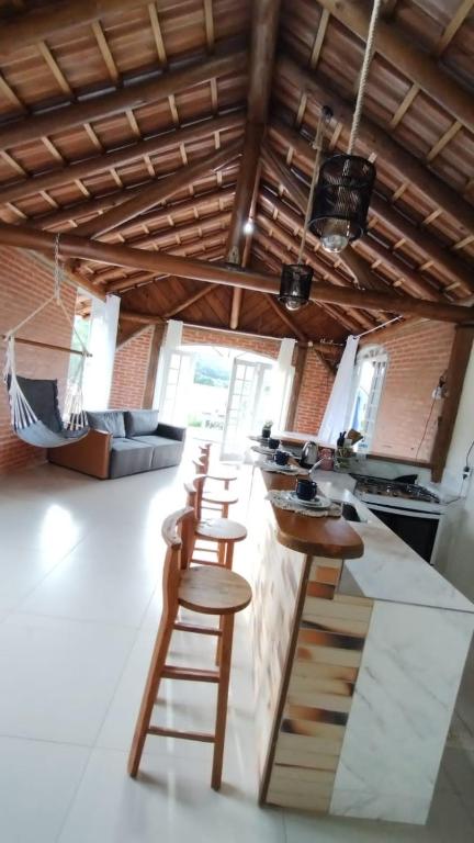 a kitchen with a counter and stools in a room at casa de campo Chalé bela vista in Tijucas