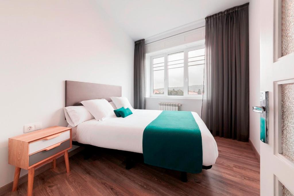 Giường trong phòng chung tại Lux Apartamentos Santiago