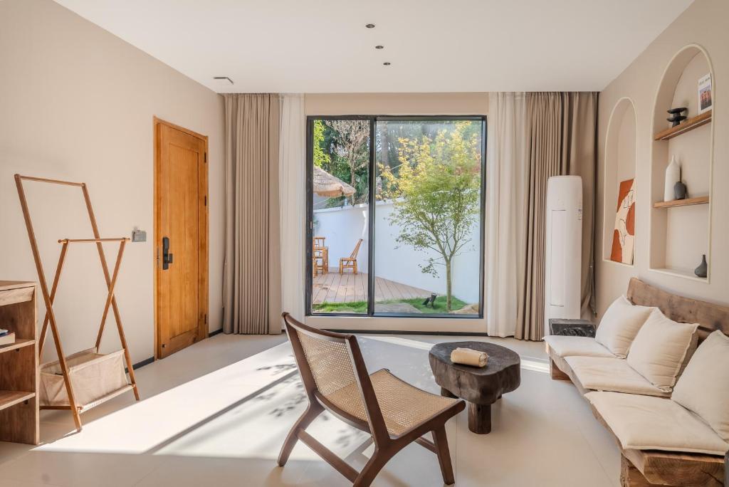 a living room with a couch and a table at Eden Yard Boutique Hotel in Xianghu