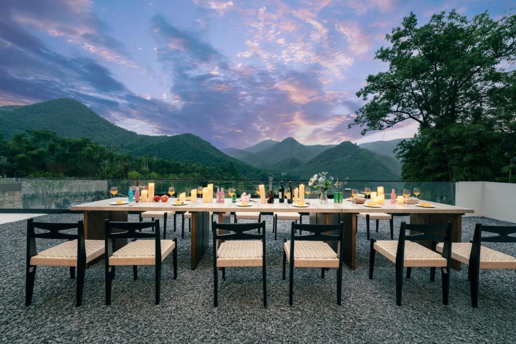 a dining table and chairs with a view of mountains at Wild Persimmon Manor Cove Mist Healing Hot Spring in Anji