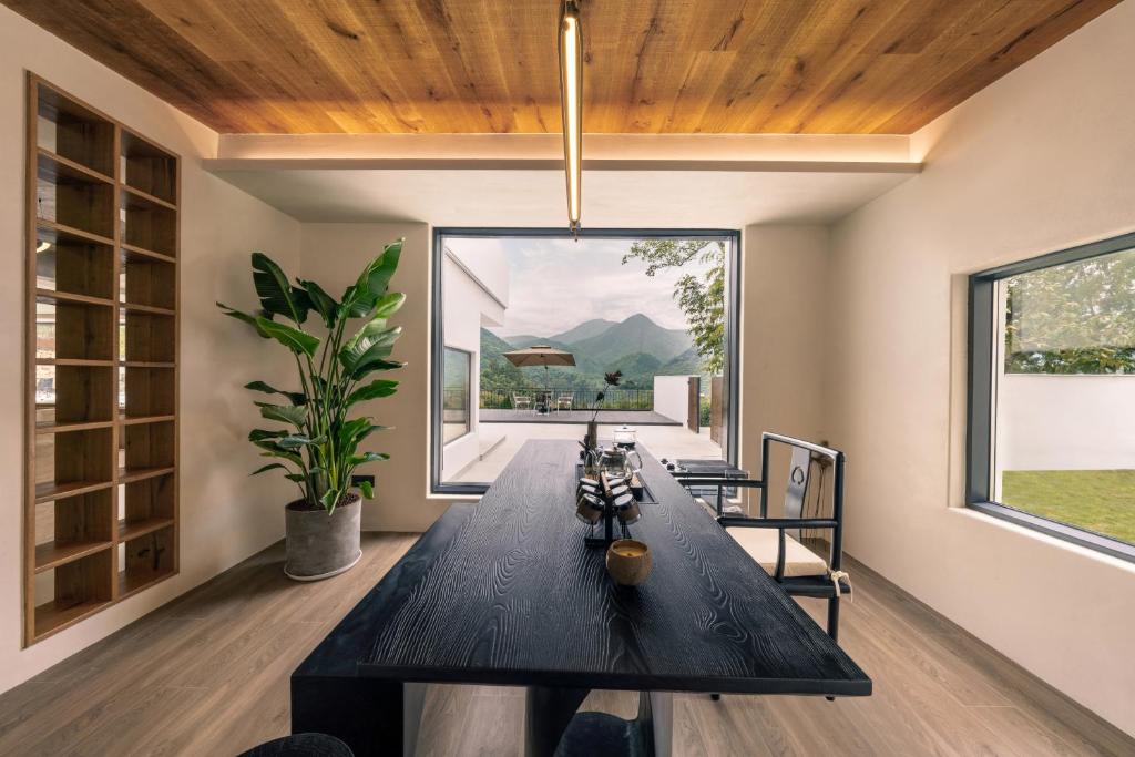 a dining room with a table and a large window at Wild Persimmon Manor Cove Mist Healing Hot Spring in Anji