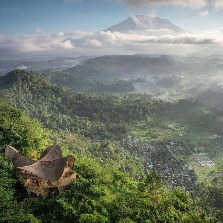 a view of a mountain with a building on a hill at Laputa Bali in Sidemen