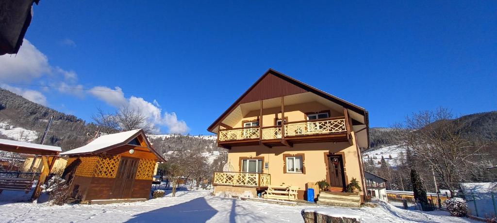 a house in the snow with a balcony on it at Апартаменти в садибі Черемош in Krivorovnya