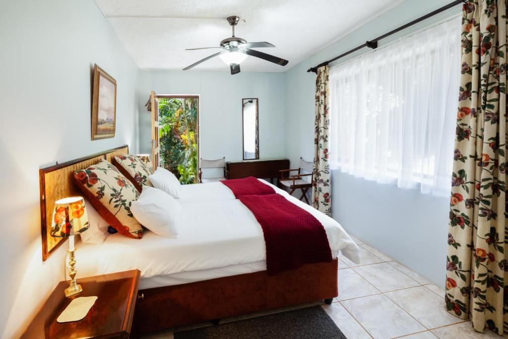 una camera da letto con un letto grande e una finestra di Summer Place Guest House a Port Edward