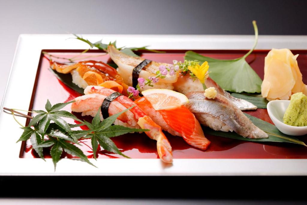a plate of food with fish and other foods at Kanazawa Hakuchoro Hotel Sanraku -Natural Hot Spring- in Kanazawa