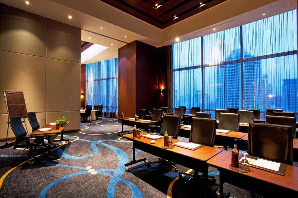 ein Konferenzraum mit Tischen und Stühlen und großen Fenstern in der Unterkunft Centara Grand At CentralWorld in Bangkok