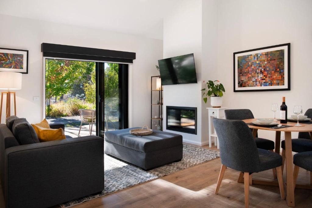 a living room with a couch and a table at Cosy Edge- charming studio on edge of town in Daylesford