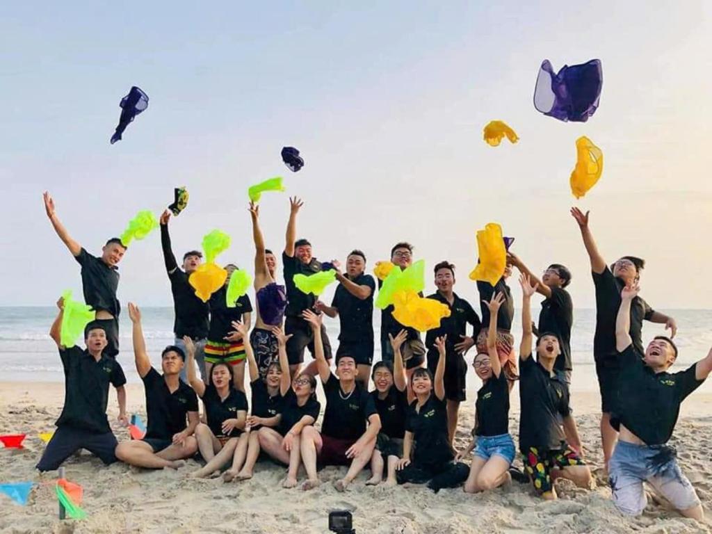 a group of people on the beach with their hands in the air at Vườn Dừa Cam Bình 1 in La Gi